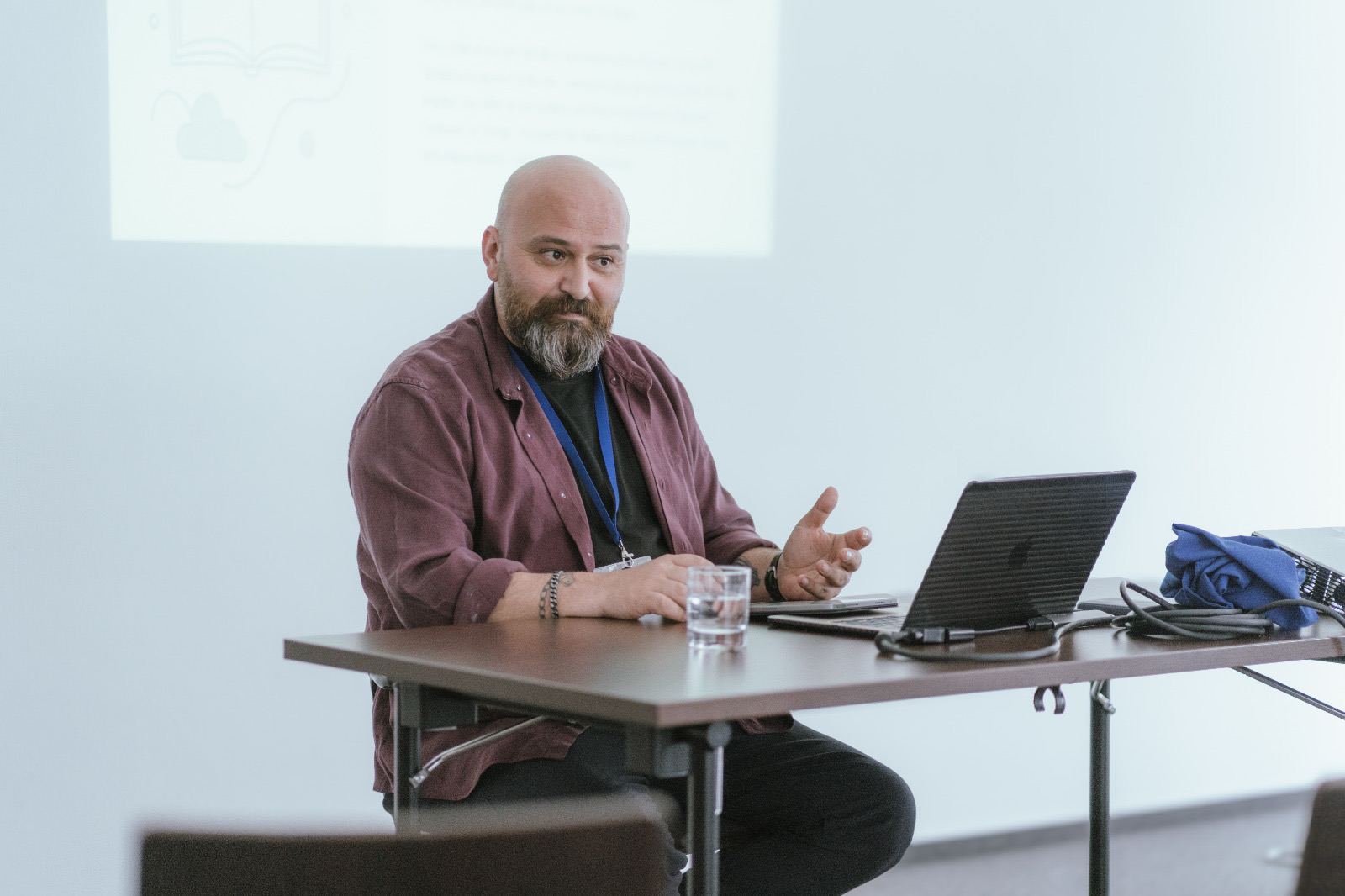 Gökhan Talas speaking at a workshop, seated with a laptop